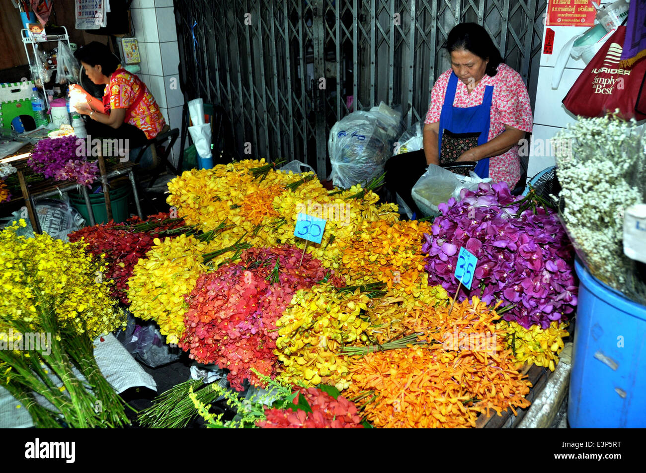 BANGKOK, THAILAND: Woman at her stall selling multi-coloured Orchids at the Bangkok flower market Stock Photo