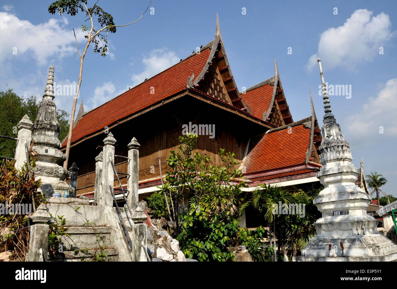 Ayutthaya, Thaialnd: White Chedis stand outside a teak wood monastic house with high gables and chofahs at c. 1503 Wat Na Phrama Stock Photo