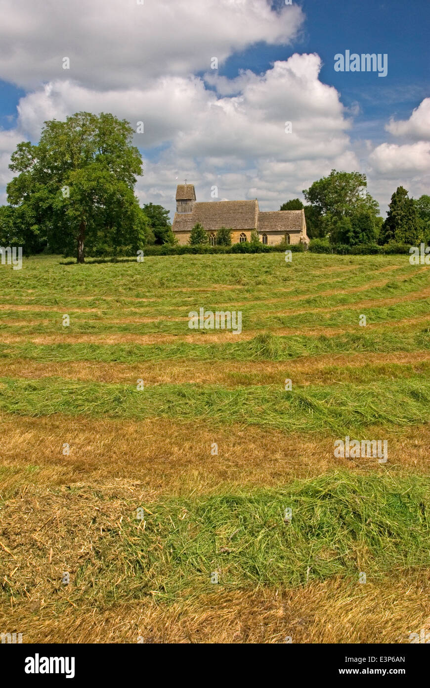 Village church in  the village of Long Marston overlooks a freshly mown meadow. Stock Photo