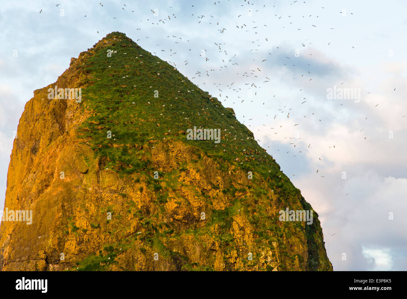 Morning sunrise light breaks thru the clouds and strikes Haystack Rock in Cannon Beach, Oregon, USA Stock Photo