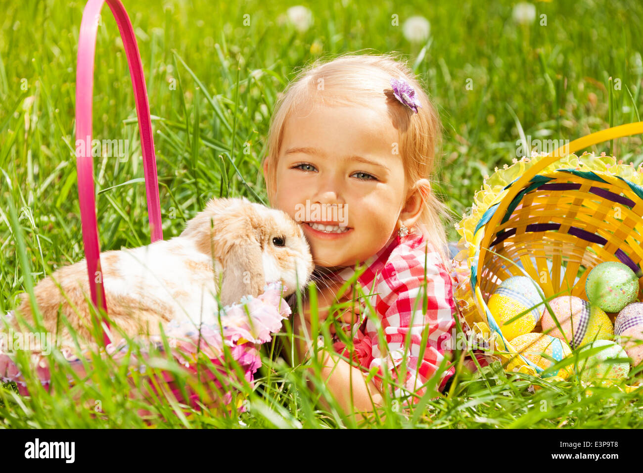 Cute small girl cuddling rabbit in field Stock Photo - Alamy
