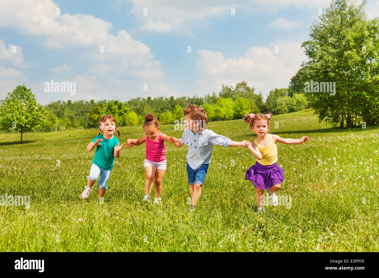 Four kids holding hands and standing together Stock Photo