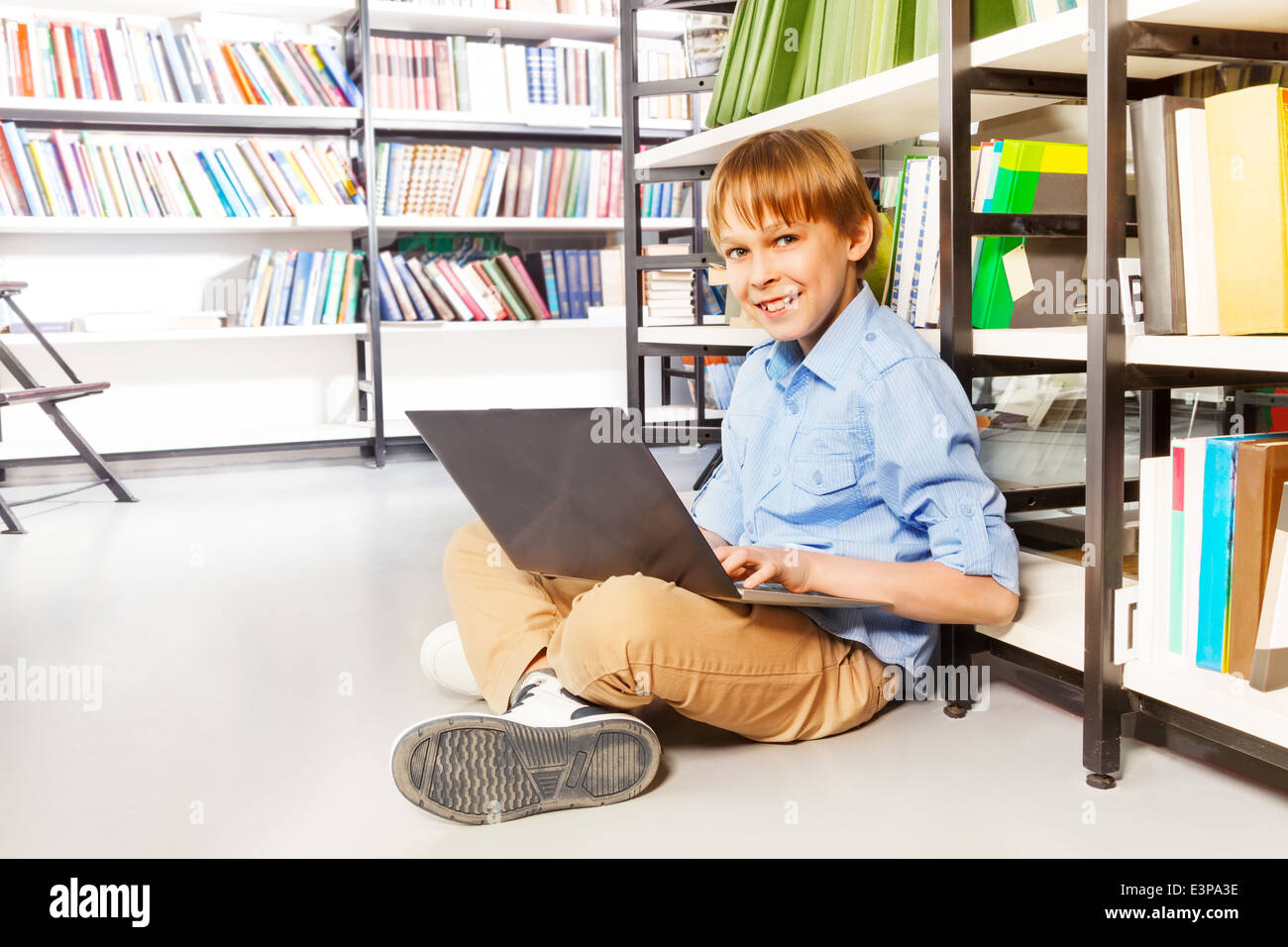 Happy boy sitting with laptop on the floor Stock Photo - Alamy