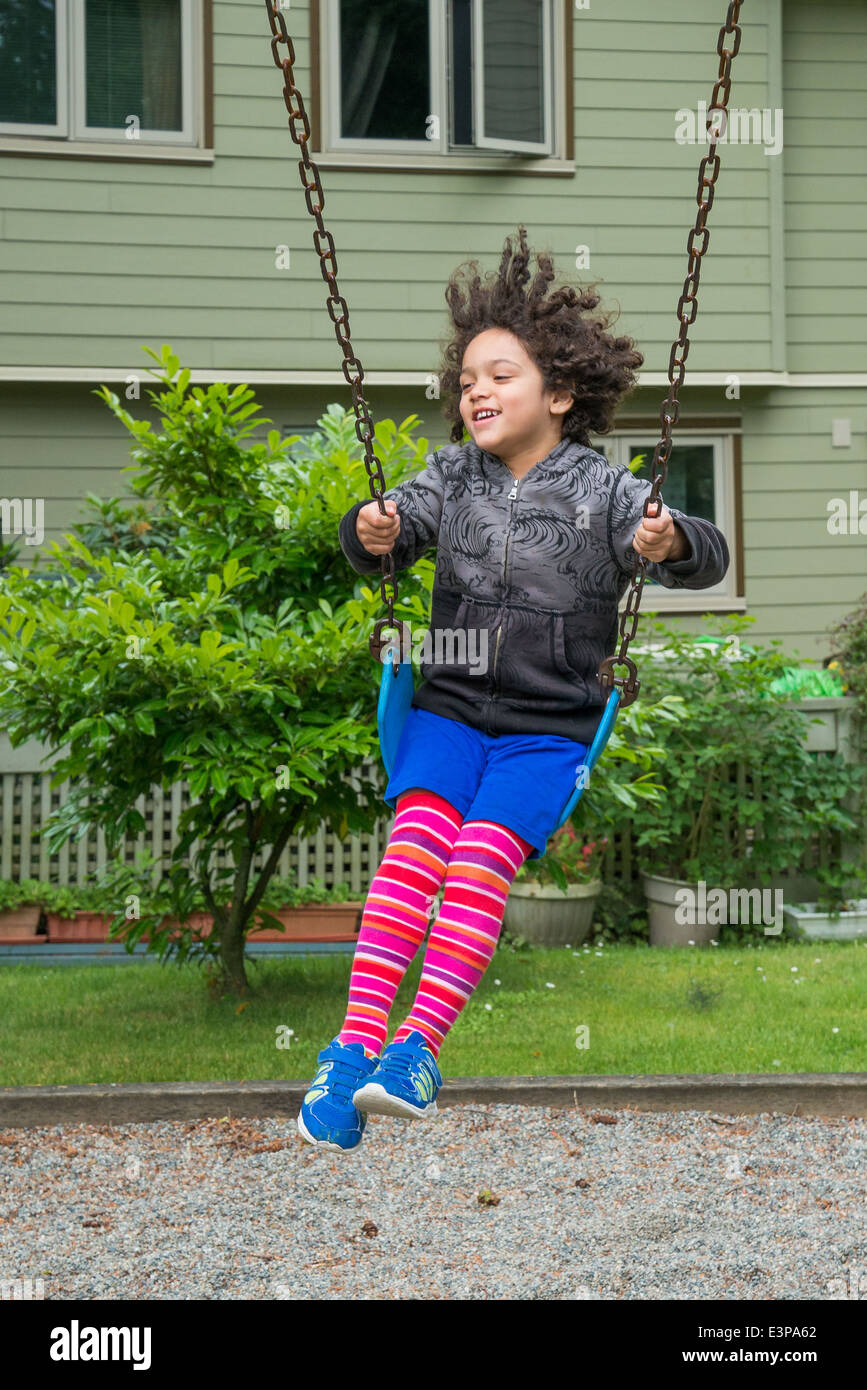 Young boy on playground swing. Stock Photo
