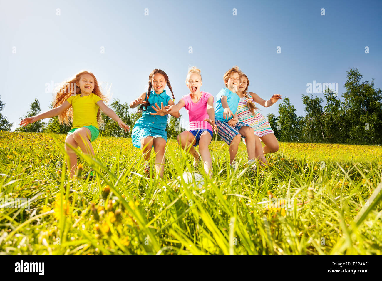 Happy children playing football in yellow meadow Stock Photo - Alamy