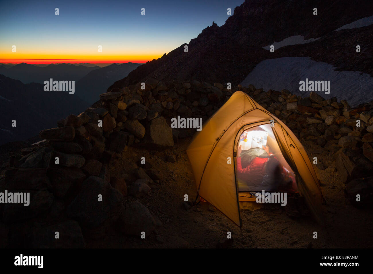 USA, Washington State. Relaxing in the tent at camp, sunset below ...