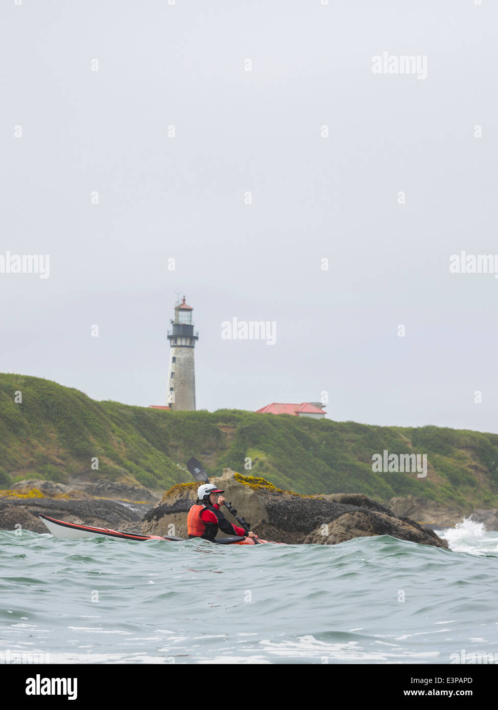USA, Washington State. Woman sea kayaker and lighthouse, Destruction ...