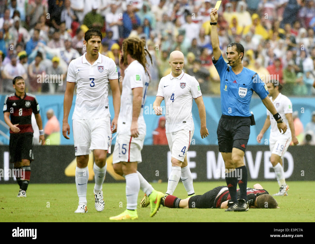 Recife, Brazil. 26th June, 2014. Uzbekistan's referee Ravshan Irmatov (1st R, front) shows a yellow card to Omar Gonzalez of the U.S. (1st L, front) during a Group G match between the U.S. and Germany of 2014 FIFA World Cup at the Arena Pernambuco Stadium in Recife, Brazil, on June 26, 2014. Credit:  Lui Siu Wai/Xinhua/Alamy Live News Stock Photo