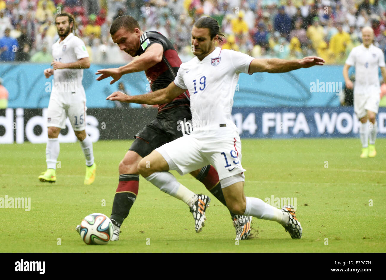 Recife, Brazil. 26th June, 2014. Germany's Lukas Podolski (L, front) vies with Graham Zusi of the U.S. (R, front) during a Group G match between the U.S. and Germany of 2014 FIFA World Cup at the Arena Pernambuco Stadium in Recife, Brazil, on June 26, 2014. Credit:  Lui Siu Wai/Xinhua/Alamy Live News Stock Photo