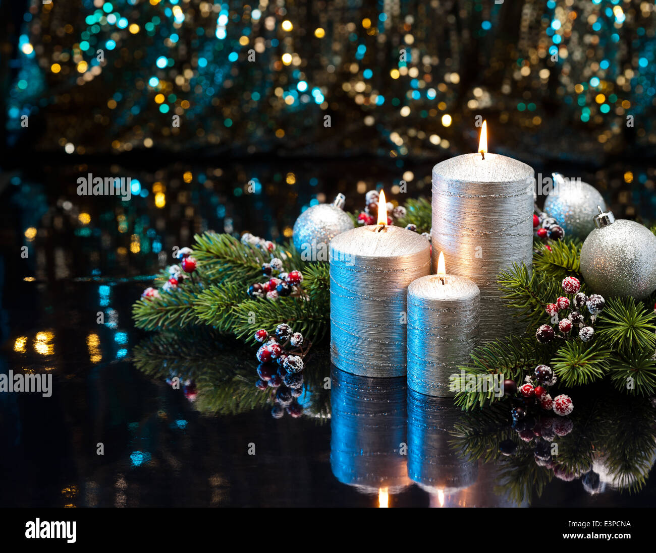 Three Silver Candles with Christmas tree branches and baubles decorated Stock Photo
