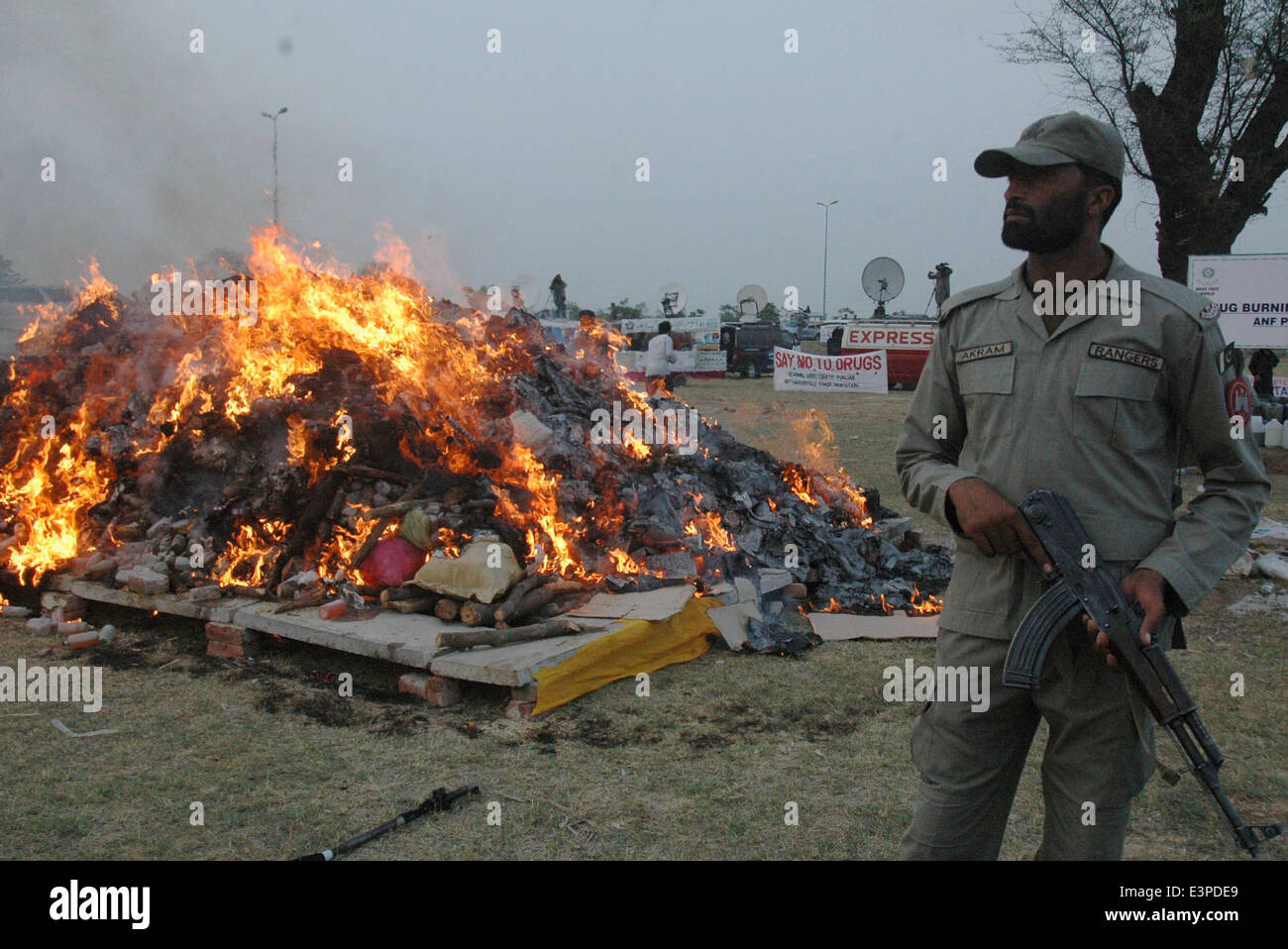 Lahore. 26th June, 2014. A Pakistani paramilitary soldier stands guard beside a burning pile of drugs in eastern Pakistan's Lahore June 26, 2014, on International Day against Drug Abuse and Illicit Trafficking. Credit:  Sajjad/Xinhua/Alamy Live News Stock Photo