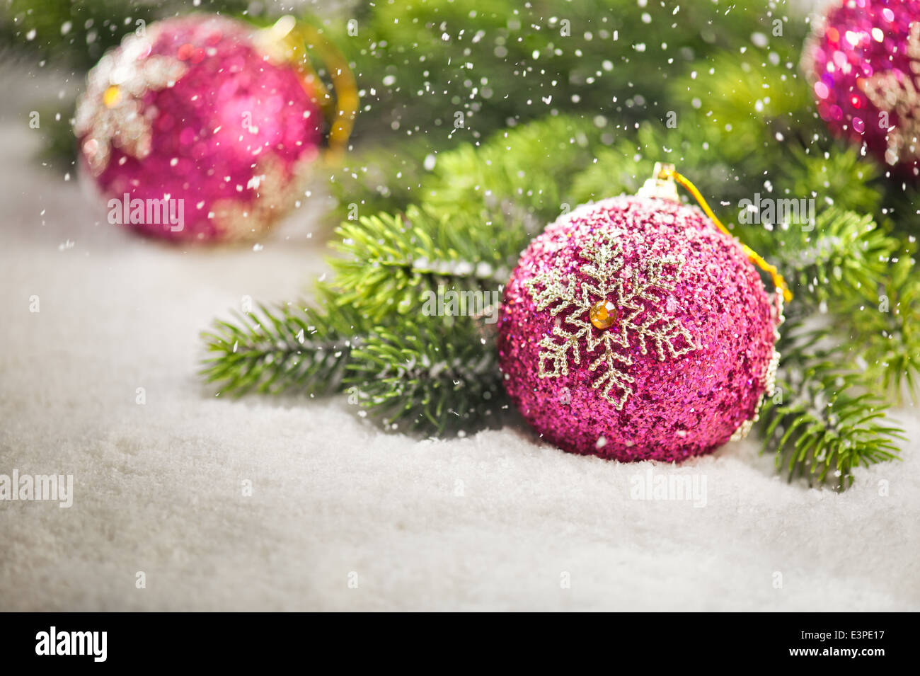 Christmas tree bauble with snow falling and Christmas tree branches