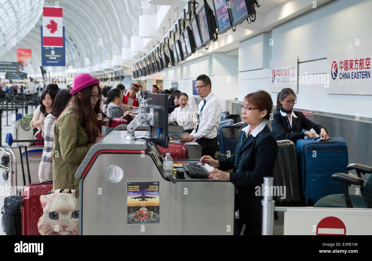 Toronto, Canada. 25th June, 2014. Passengers check in at China Eastern Airlines booth at Pearson International Airport in Toronto, Canada, June 25, 2014. China Eastern Airlines launched its direct flight between Shanghai, east China, and Toronto on Wednesday. © Zou Zheng/Xinhua/Alamy Live News Stock Photo