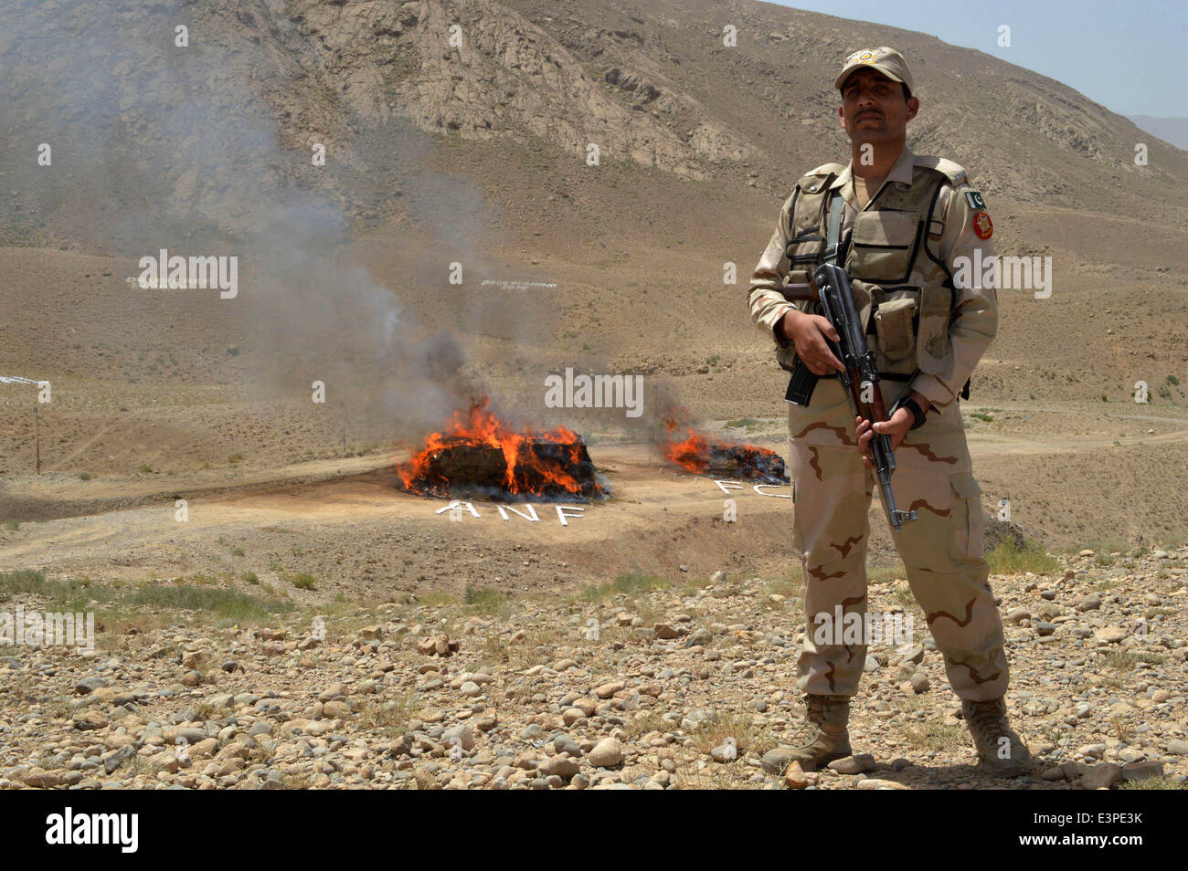 Quetta. 26th June, 2014. A Pakistani paramilitary soldier stands guard beside a burning pile of drugs during a ceremony to mark the International Day Against Drug Abuse and Illicit Trafficking, in southwest Pakistan's Quetta on June 26, 2014. Credit:  Irfan/Xinhua/Alamy Live News Stock Photo