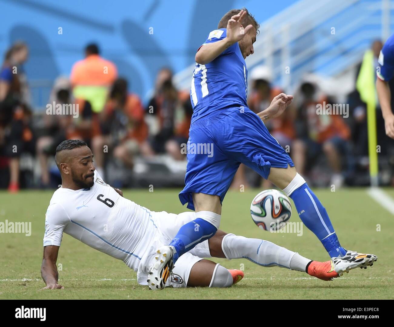 Natal, Brazil. 24th June, 2014. Italy's Ciro Immobile vies with Uruguay's Alvaro Pereira during a Group D match between Italy and Uruguay of 2014 FIFA World Cup at the Estadio das Dunas Stadium in Natal, Brazil, June 24, 2014. © Lui Siu Wai/Xinhua/Alamy Live News Stock Photo