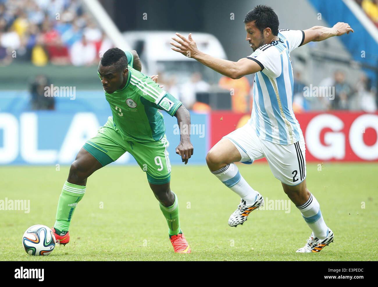 Porto Alegre, Brazil. 25th June, 2014. Nigeria's Emmanuel Emenike (L) vies with Argentina's Ezequiel Garay during a Group F match between Nigeria and Argentina of 2014 FIFA World Cup at the Estadio Beira-Rio Stadium in Porto Alegre, Brazil, on June 25, 2014. © Chen Jianli/Xinhua/Alamy Live News Stock Photo