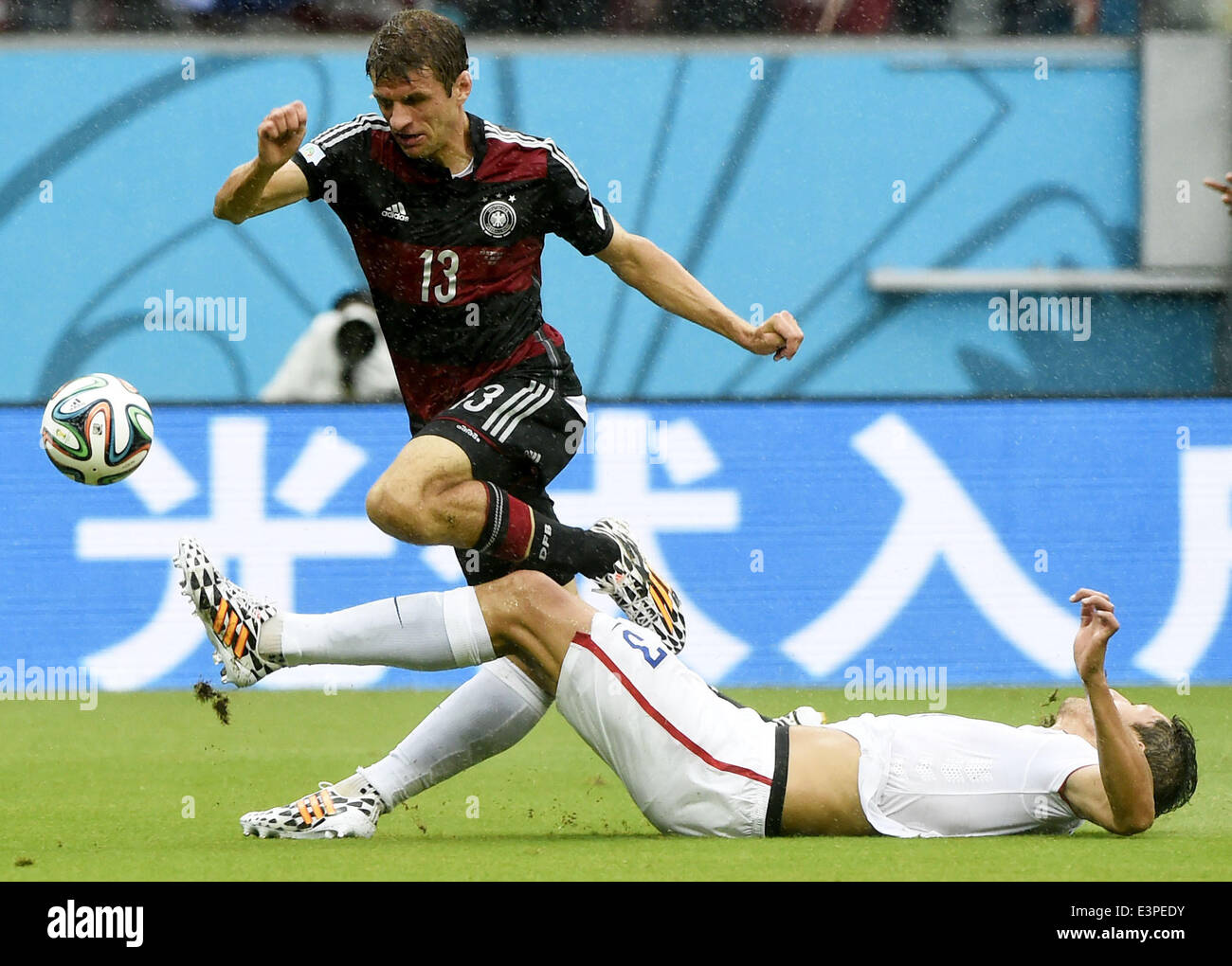 Recife, Brazil. 26th June, 2014. Omar Gonzalez of the U.S. (R) tackles the ball controlled by Germany's Thomas Muller during a Group G match between the U.S. and Germany of 2014 FIFA World Cup at the Arena Pernambuco Stadium in Recife, Brazil, on June 26, 2014. Credit:  Lui Siu Wai/Xinhua/Alamy Live News Stock Photo