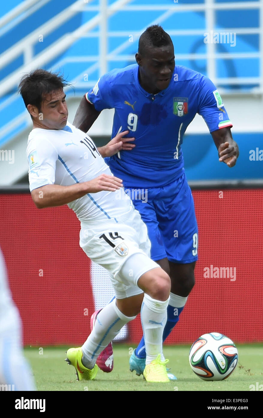 Natal, Brazil. 24th June, 2014. Italy's Mario Balotelli vies with Uruguay's Nicolas Lodeiro during a Group D match between Italy and Uruguay of 2014 FIFA World Cup at the Estadio das Dunas Stadium in Natal, Brazil, June 24, 2014. © Guo Yong/Xinhua/Alamy Live News Stock Photo