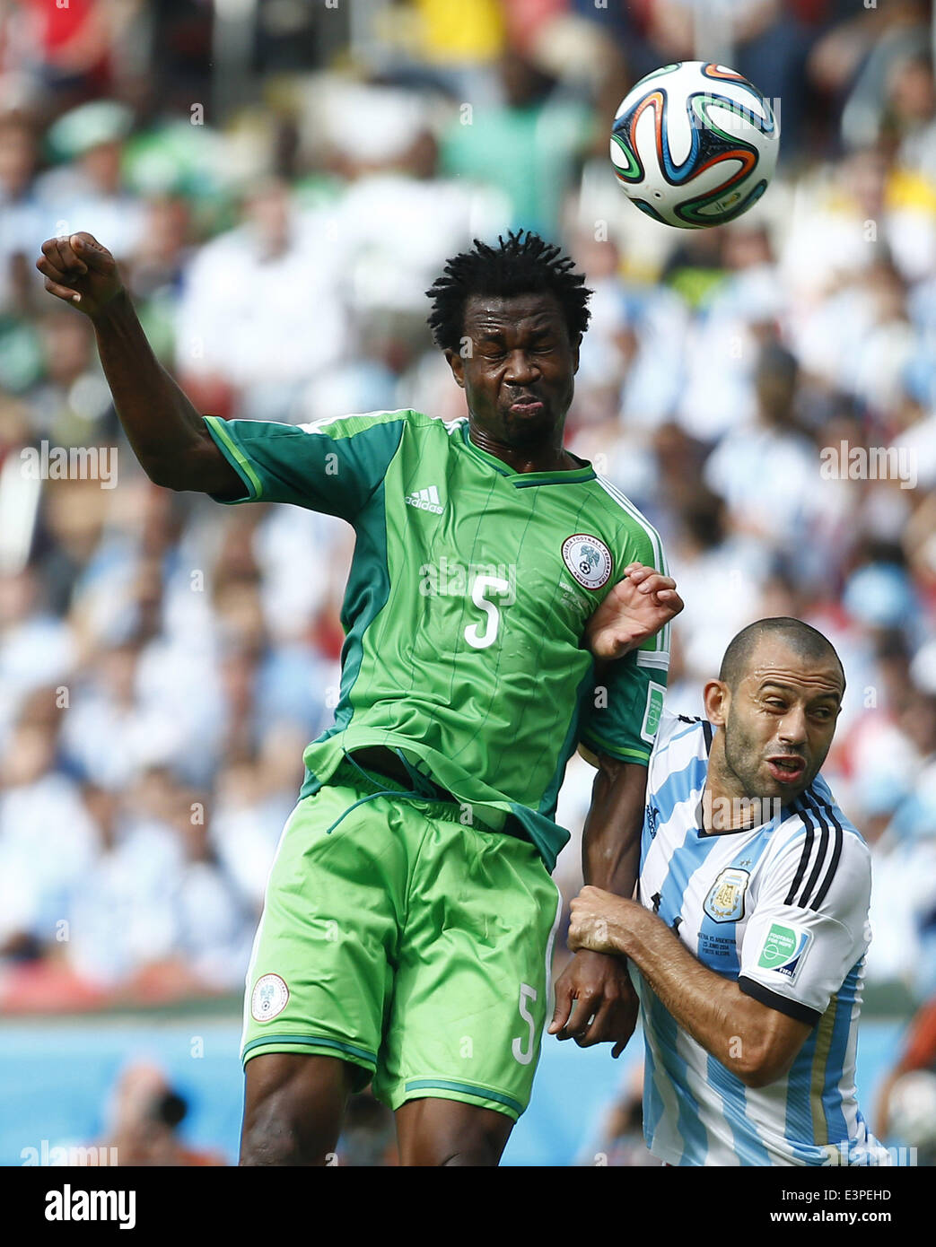 Porto Alegre, Brazil. 25th June, 2014. Nigeria's Efe Ambrose (L) competes for a header with Argentina's Javier Mascherano during a Group F match between Nigeria and Argentina of 2014 FIFA World Cup at the Estadio Beira-Rio Stadium in Porto Alegre, Brazil, on June 25, 2014. © Chen Jianli/Xinhua/Alamy Live News Stock Photo