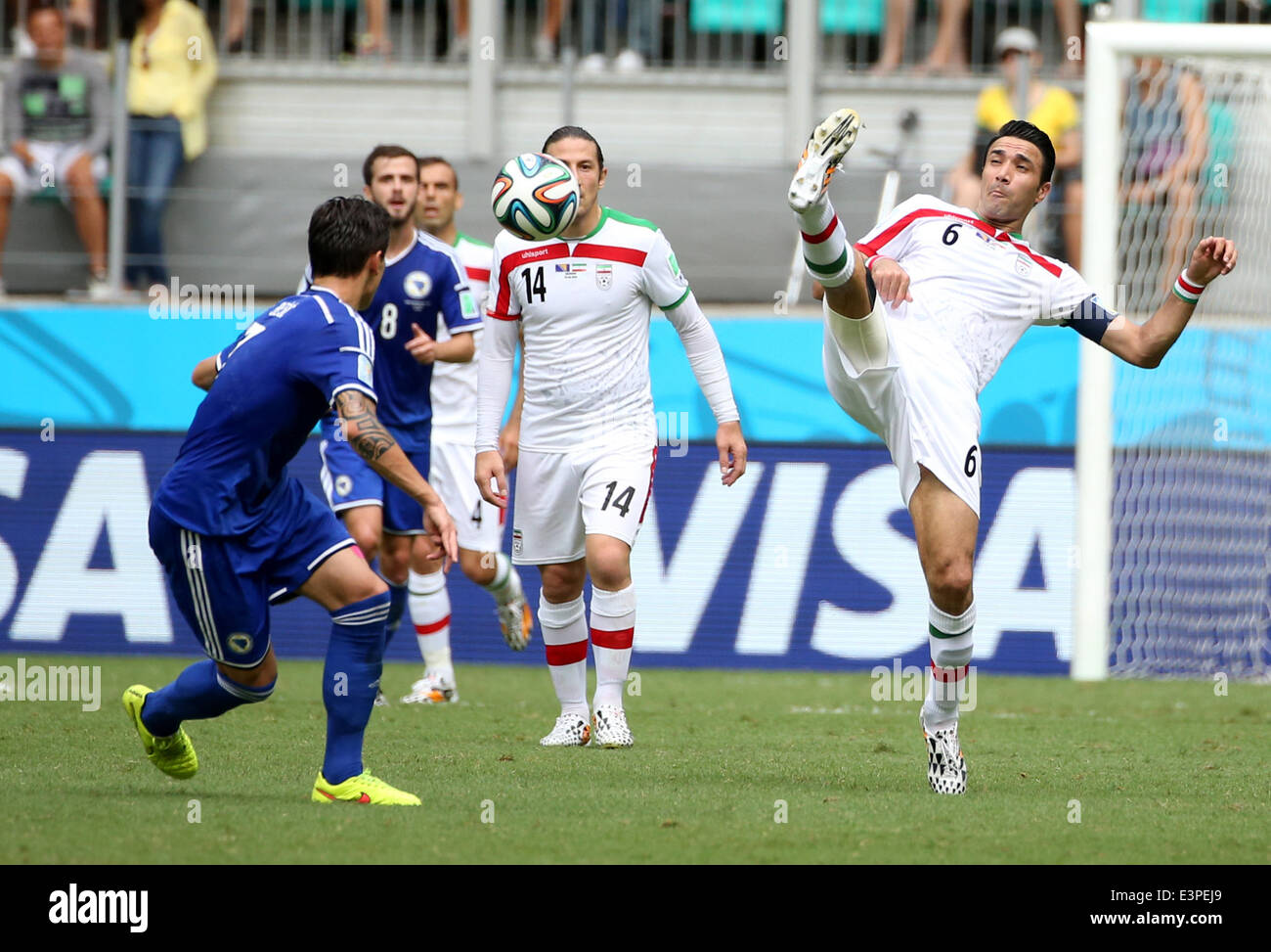 Salvador, Brazil. 24th June, 2014. Iran's Javad Nekounam (R) passes the ball during a Group F match between Bosnia And Herzegovina and Iran of 2014 FIFA World Cup at the Arena Fonte Nova Stadium in Salvador, Brazil, June 24, 2014. © Cao Can/Xinhua/Alamy Live News Stock Photo