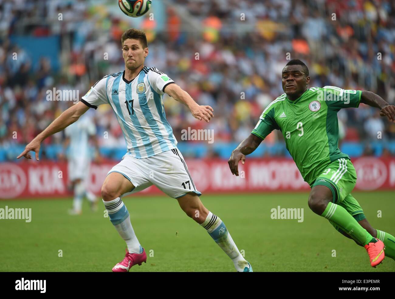 Porto Alegre, Brazil. 25th June, 2014. Argentina's Federico Fernandez (L) vies with Nigeria's Emmanuel Emenike during a Group F match between Nigeria and Argentina of 2014 FIFA World Cup at the Estadio Beira-Rio Stadium in Porto Alegre, Brazil, on June 25, 2014. © Li Ga/Xinhua/Alamy Live News Stock Photo