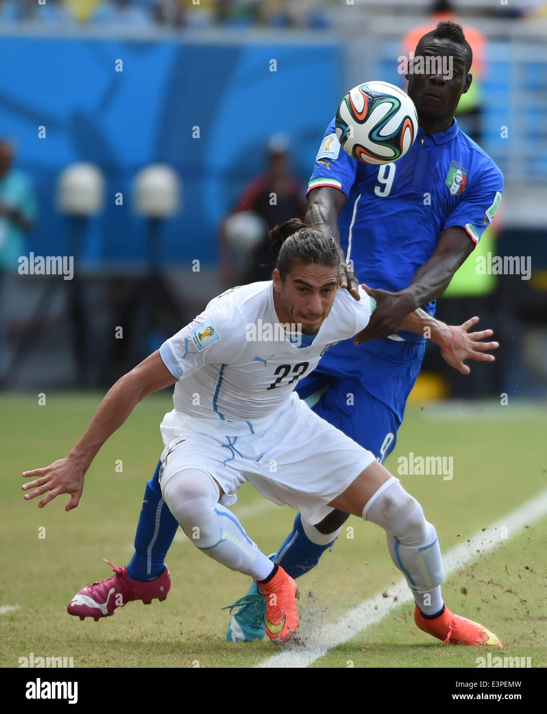 Natal, Brazil. 24th June, 2014. Italy's Mario Balotelli vies with Uruguay's Martin Caceres during a Group D match between Italy and Uruguay of 2014 FIFA World Cup at the Estadio das Dunas Stadium in Natal, Brazil, June 24, 2014. © Guo Yong/Xinhua/Alamy Live News Stock Photo