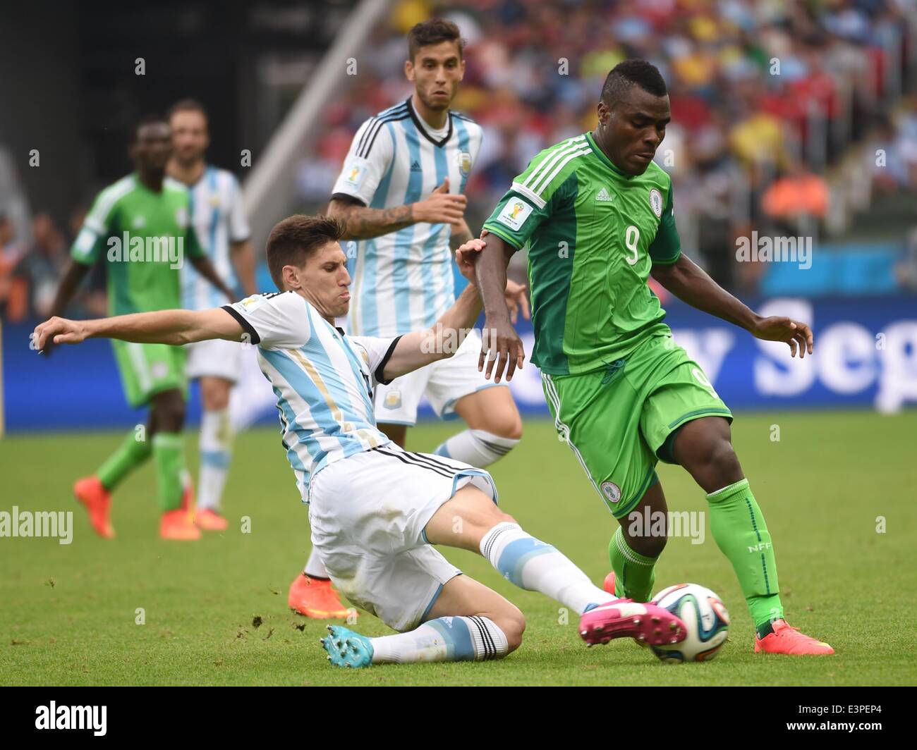 Porto Alegre, Brazil. 25th June, 2014. Argentina's Federico Fernandez (L, front) vies with Nigeria's Emmanuel Emenike during a Group F match between Nigeria and Argentina of 2014 FIFA World Cup at the Estadio Beira-Rio Stadium in Porto Alegre, Brazil, on June 25, 2014. © Li Ga/Xinhua/Alamy Live News Stock Photo