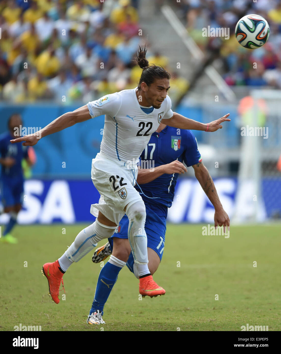 Natal, Brazil. 24th June, 2014. Uruguay's Martin Caceres vies for the ball with Italy's Ciro Immobile during a Group D match between Italy and Uruguay of 2014 FIFA World Cup at the Estadio das Dunas Stadium in Natal, Brazil, June 24, 2014. © Guo Yong/Xinhua/Alamy Live News Stock Photo
