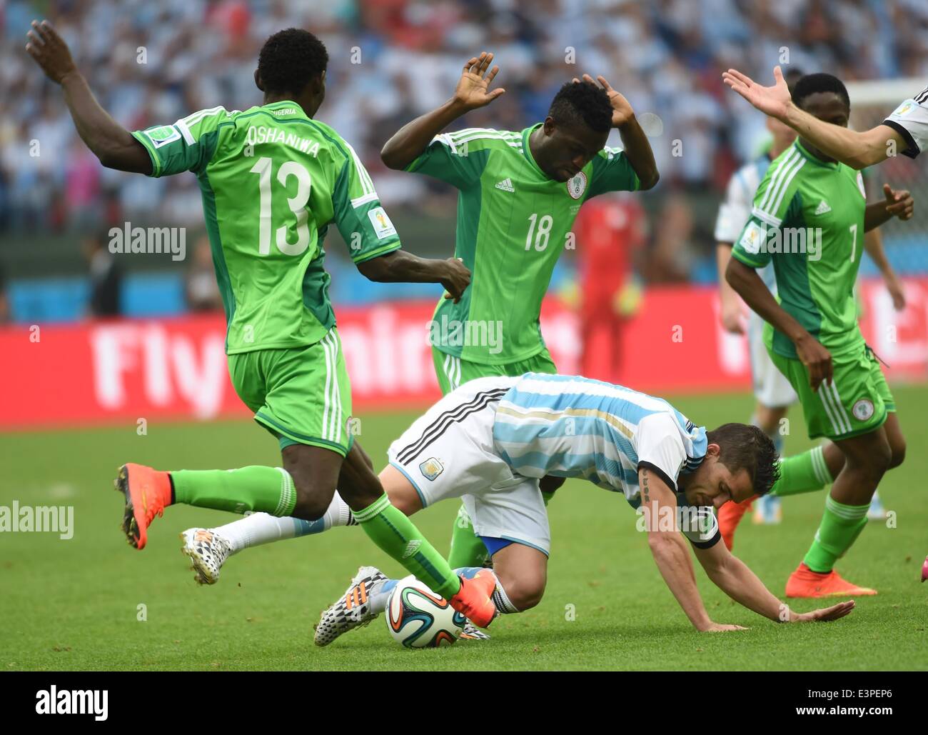 Porto Alegre, Brazil. 25th June, 2014. Argentina's Federico Fernandez (bottom) falls down in a competition with Nigeria's players during a Group F match between Nigeria and Argentina of 2014 FIFA World Cup at the Estadio Beira-Rio Stadium in Porto Alegre, Brazil, on June 25, 2014. © Li Ga/Xinhua/Alamy Live News Stock Photo