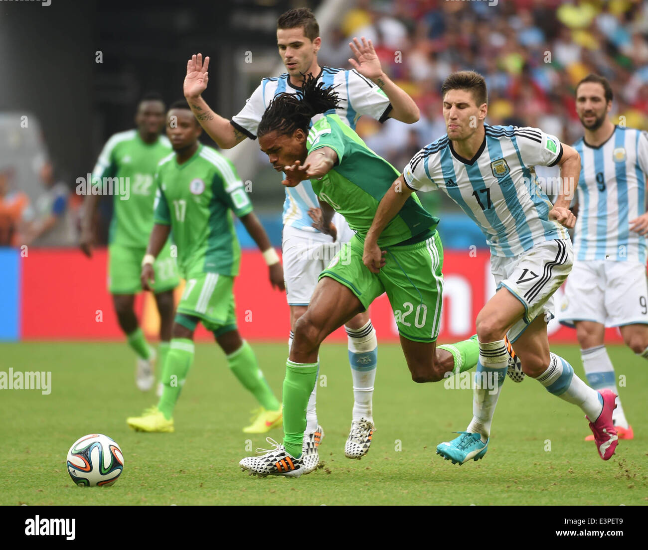Porto Alegre, Brazil. 25th June, 2014. Nigeria's Michael Uchebo (C, front) competes with Argentina's Federico Fernandez (R, front) during a Group F match between Nigeria and Argentina of 2014 FIFA World Cup at the Estadio Beira-Rio Stadium in Porto Alegre, Brazil, on June 25, 2014. Argentina won 3-2 over Nigeria on Wednesday. © Li Ga/Xinhua/Alamy Live News Stock Photo
