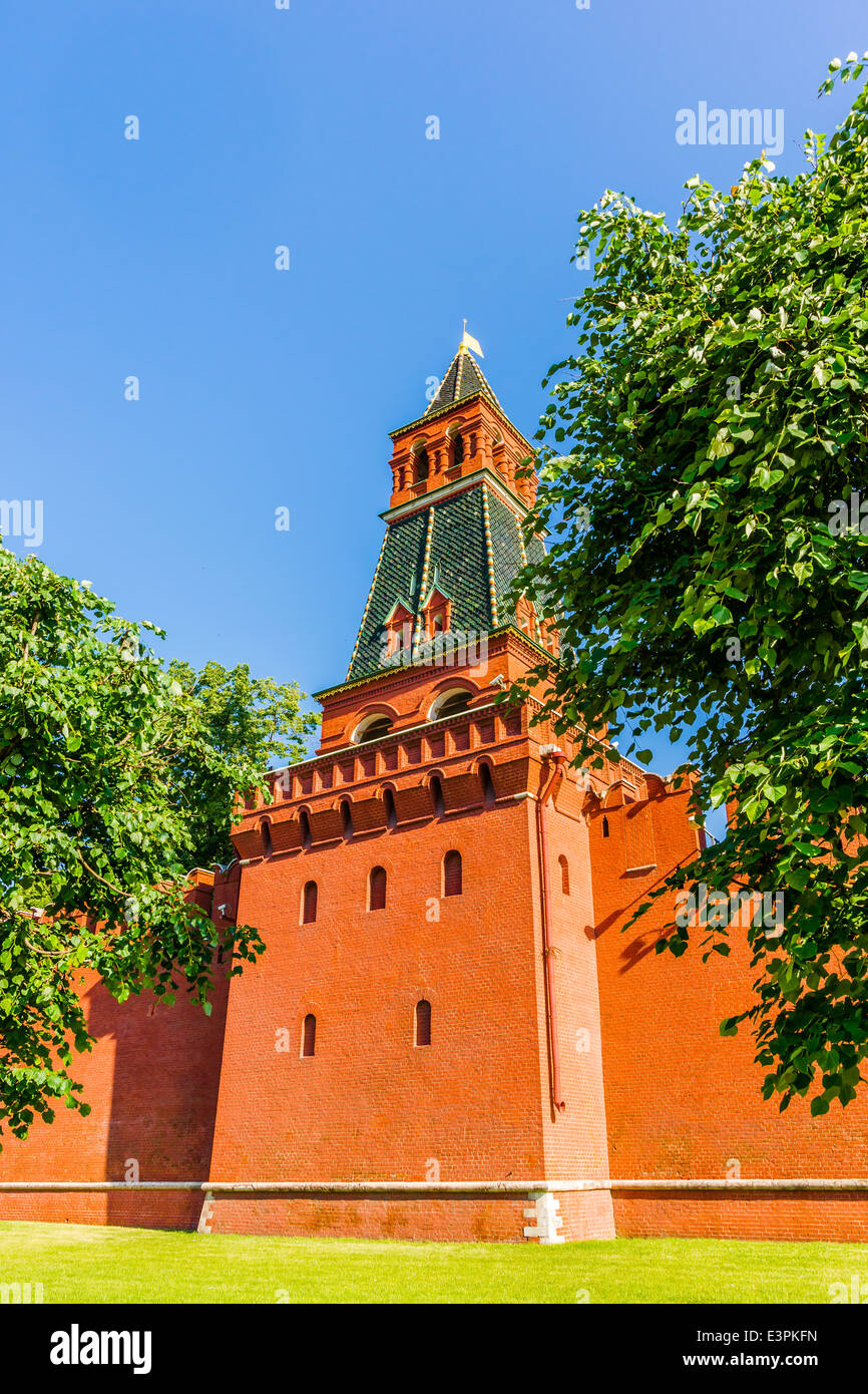 Second Unnamed tower of Moscow Kremlin against clear blue sky and amidst green grass and trees Stock Photo
