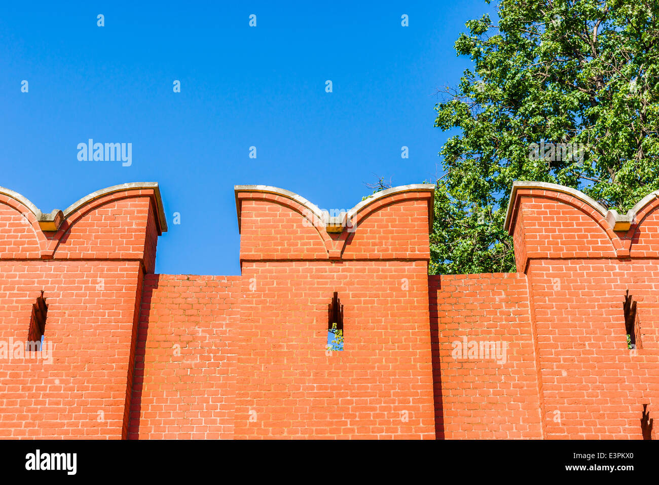Closeup view and top part of Moscow Kremlin wall of red bricks against clear blue sky Stock Photo