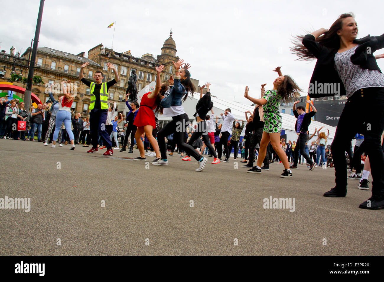 Glasgow, Scotland, UK. 27th June, 2014. A flashmob of 100 dancers heralds the opening of the official games merchandise superstore by Chief Executive David Grevemberg Credit:  ALAN OLIVER/Alamy Live News Stock Photo