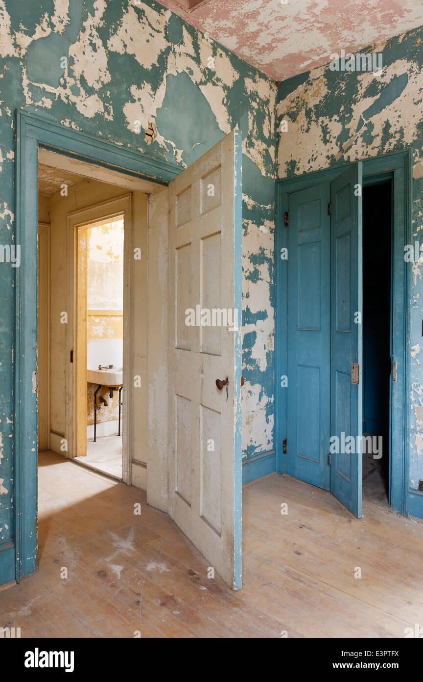 Open door in room with cracked and peeling wall paint Stock Photo