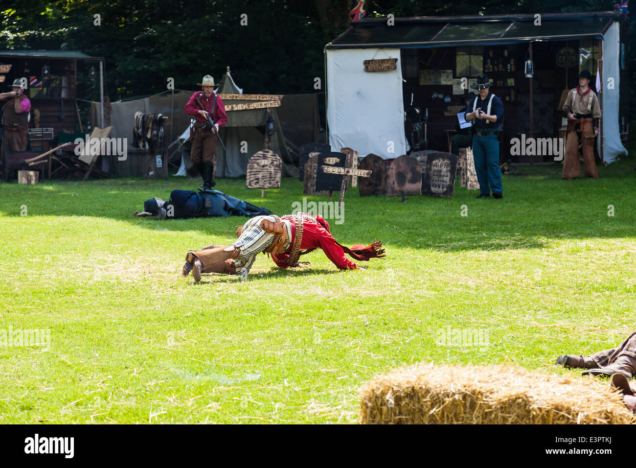 Leek, Staffordshire, England. 22nd June 2014, A Western Weekend. Outlaw falls to the ground after shootout. Western reenactment Stock Photo