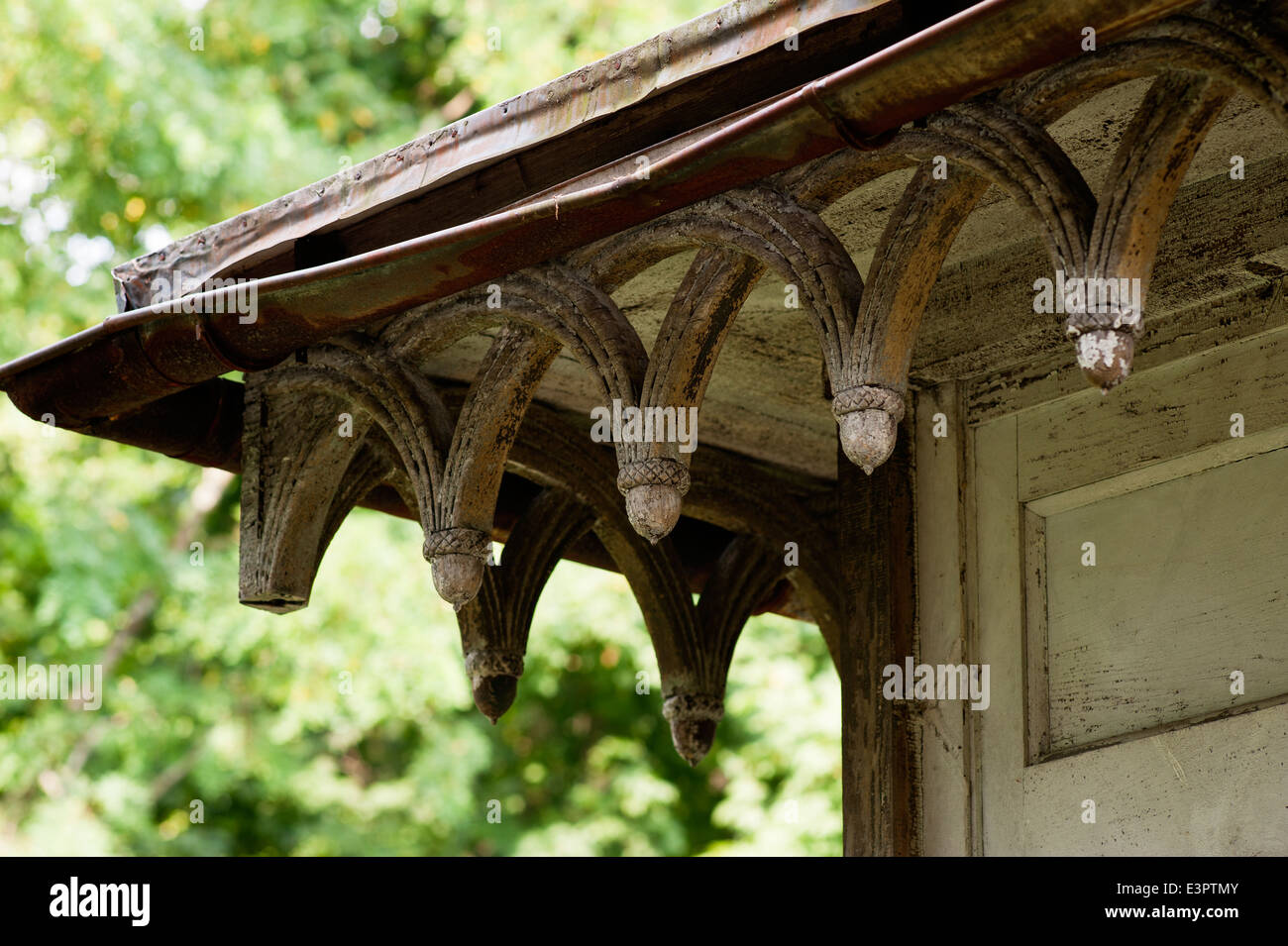 Detail of acorn style sculptures on distressed eaves Stock Photo