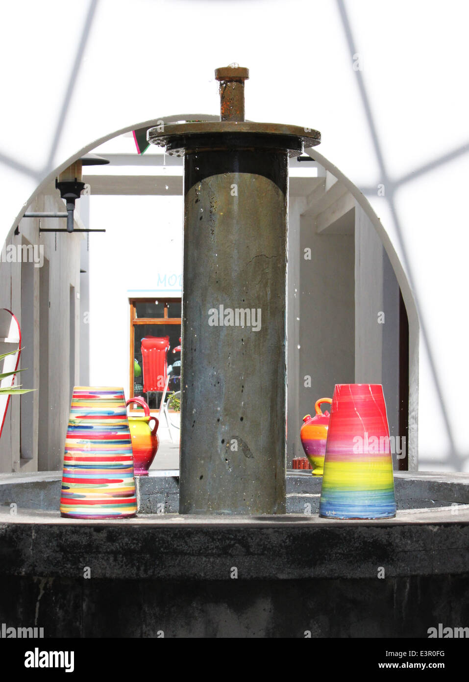 multicolored vases underneath a fountain in Lanzarote Stock Photo