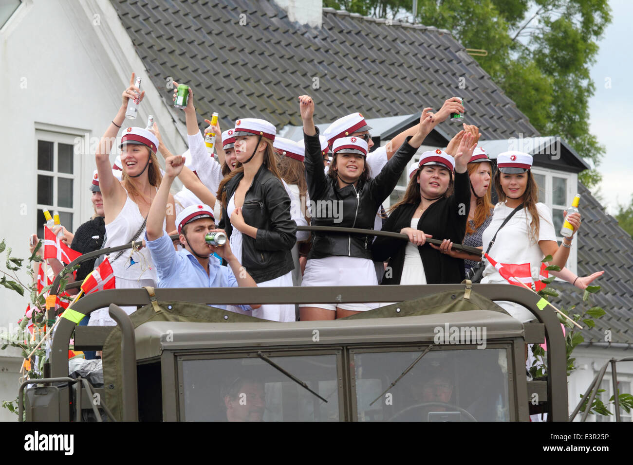Vedbæk / Vedbaek,  north of Copenhagen, Denmark. June 27, 2014. Danish students in white student caps celebrate their high school, grammar school exams on the traditional and high-spirited tour on the back of a truck. Each student's home will be visited for celebration and refreshments on this extremely long  and often more than daylong and high-spirited tour. Music, horns, alcohol and other road users’ participation are important. Credit:  Niels Quist/Alamy Live News Stock Photo