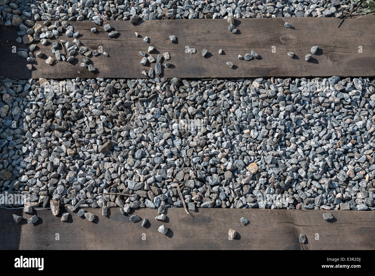 The dirty macadam and old wooden ties of the railway as a background. Stock Photo