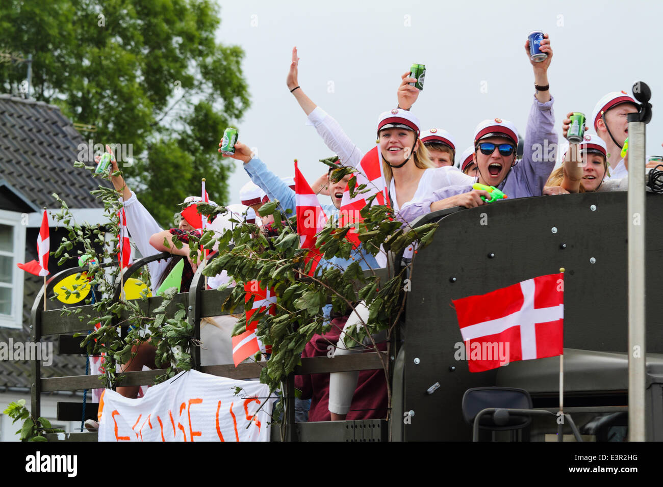Vedbæk / Vedbaek,  north of Copenhagen, Denmark. June 27, 2014. Danish students in white student caps celebrate their high school, grammar school  exams on the traditional and high-spirited tour on the back of a truck. Each student's home will be visited for celebration and refreshments on this extremely long  and often more than daylong and high-spirited tour. Music, horns, alcohol and other road users’ participation are important. Credit:  Niels Quist/Alamy Live News Stock Photo