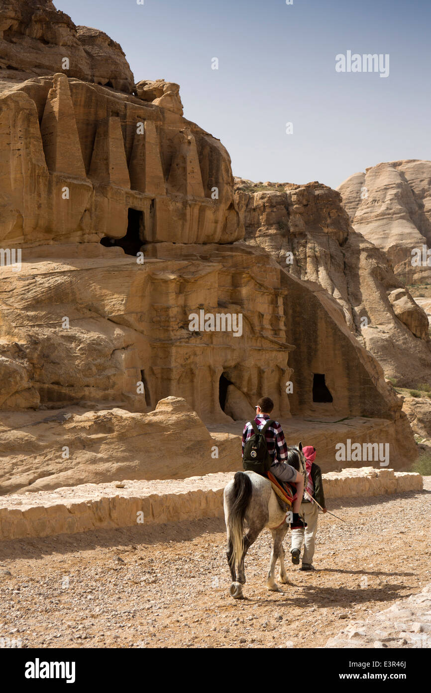 Jordan, Arabah, Petra, horses giving tourist ride to Al-Siq entrance past Obeslisk Tomb Stock Photo