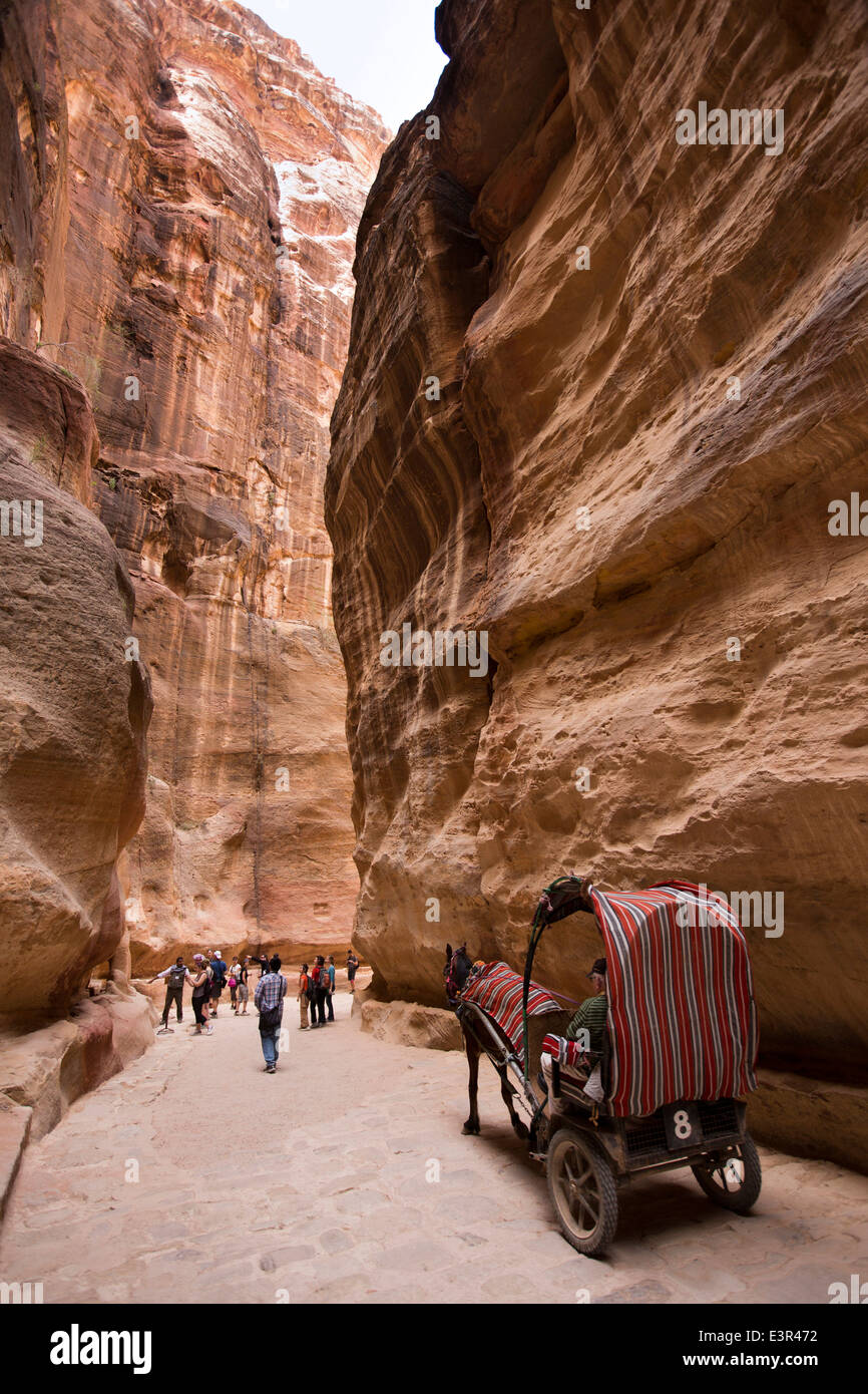 Jordan, Arabah, Petra, horse carriage and tourists walking through Al-Siq entrance canyon to site Stock Photo
