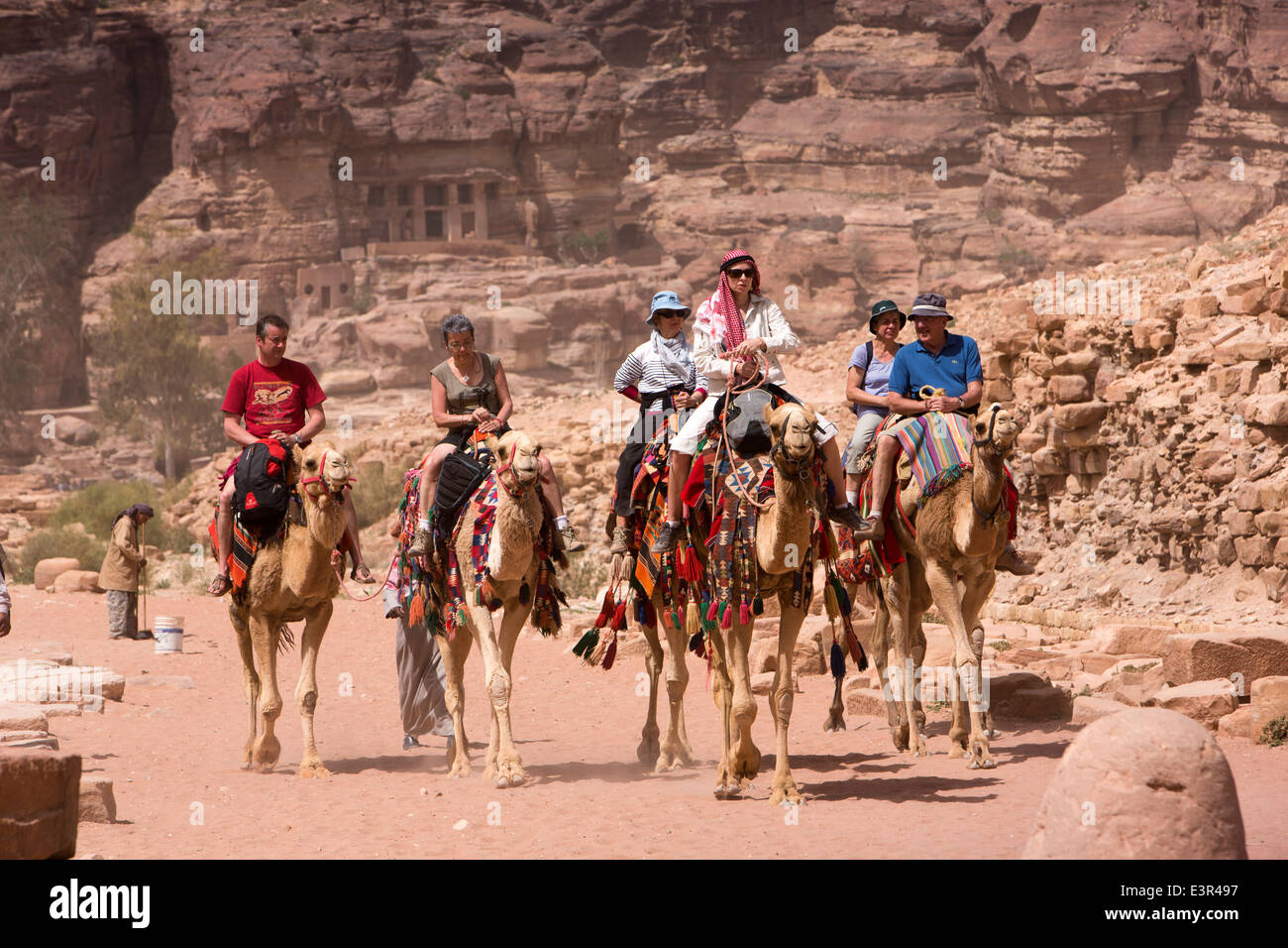 Jordan, Arabah, Petra, tourists riding camels though the UNESCO World  Heritage Site Stock Photo - Alamy