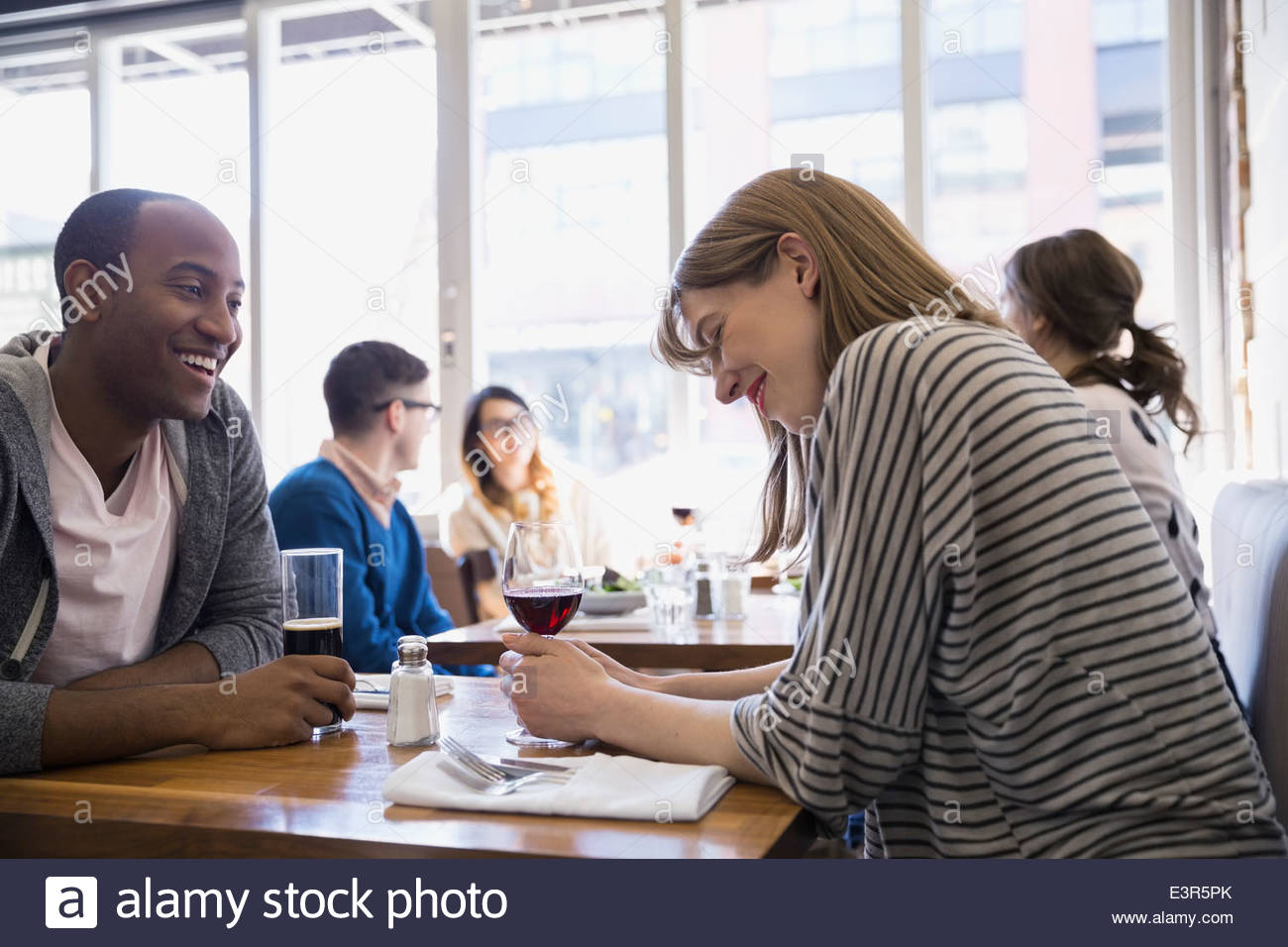Couple drinking beer and wine at bistro table Stock Photo Alamy