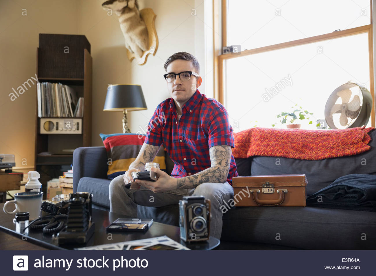 Portrait of serious man with antique cameras Stock Photo