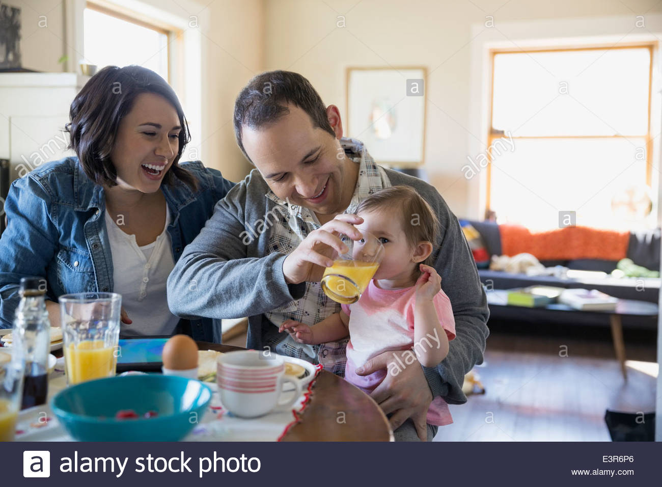 Young family enjoying breakfast at dining table Stock Photo