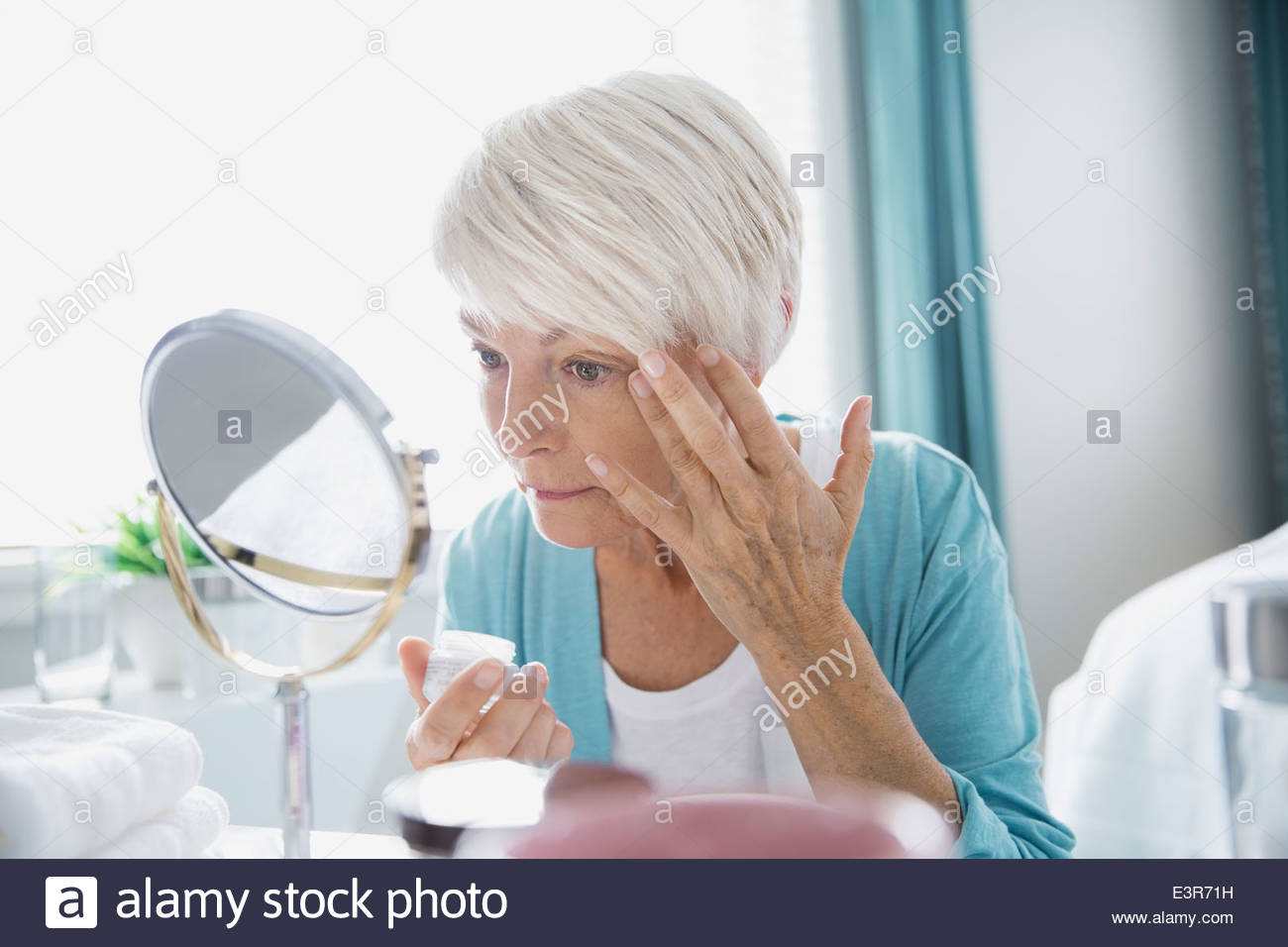 Woman applying wrinkle cream Stock Photo