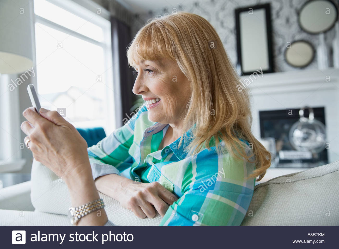Woman text messaging on sofa Stock Photo