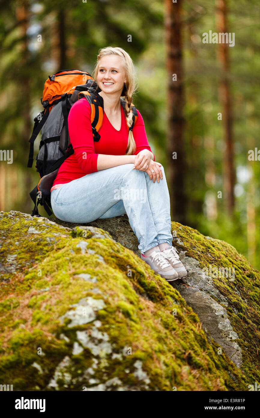 Young beautiful woman hiking in a forest, having a break. Stock Photo