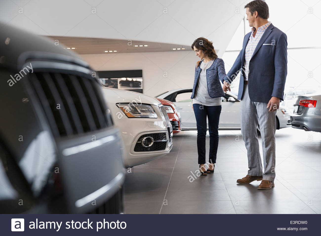 Couple shopping in car dealership showroom Stock Photo
